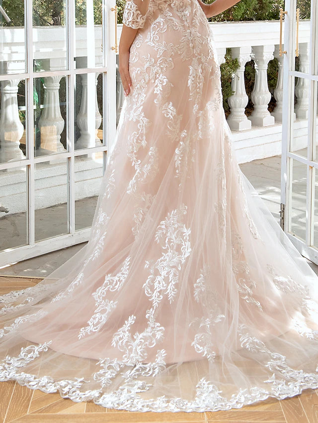 Close-up of the sweetheart neckline and long lace sleeves on the wedding gown.