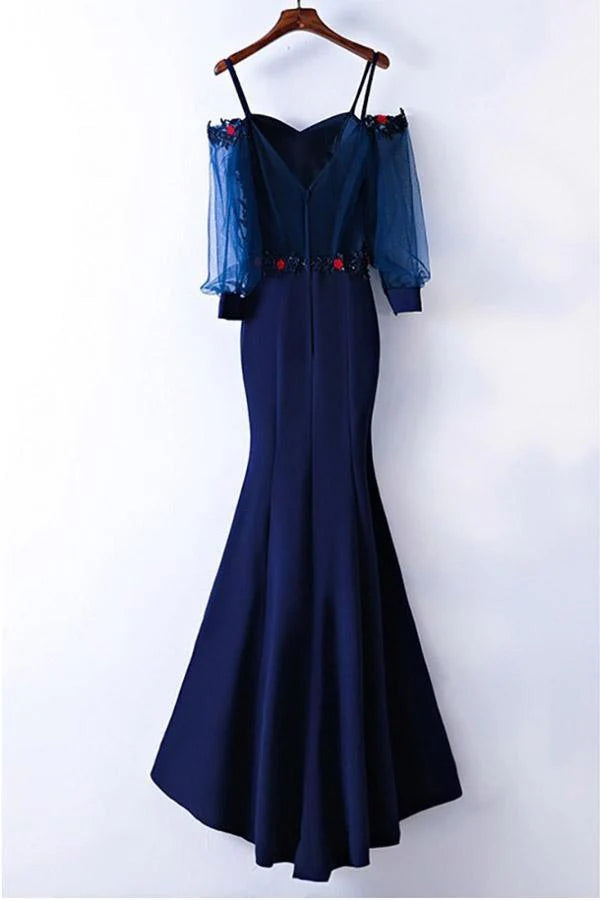 Elegant mermaid prom dress with long sleeves and intricate applique detailing on a model.