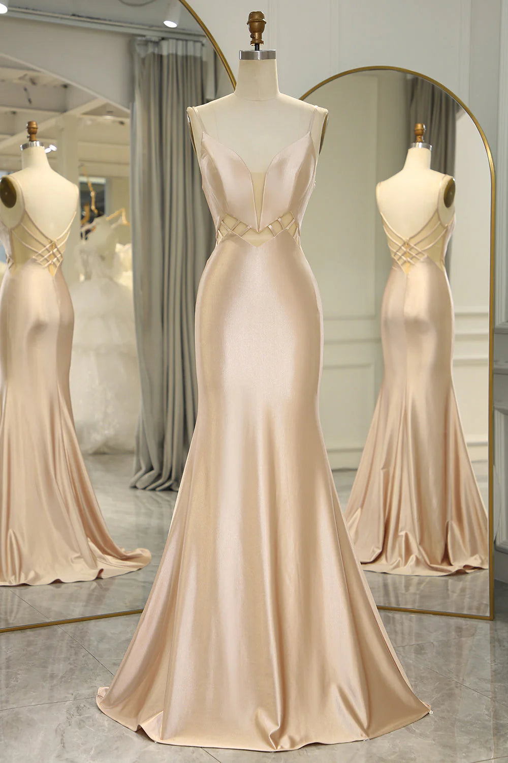 Elegant champagne mermaid prom dress with a V-neckline and backless design.