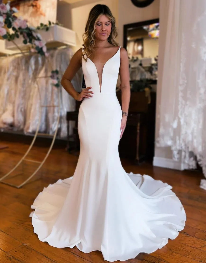 Elegant mermaid satin wedding dress with a boat neckline and train.
