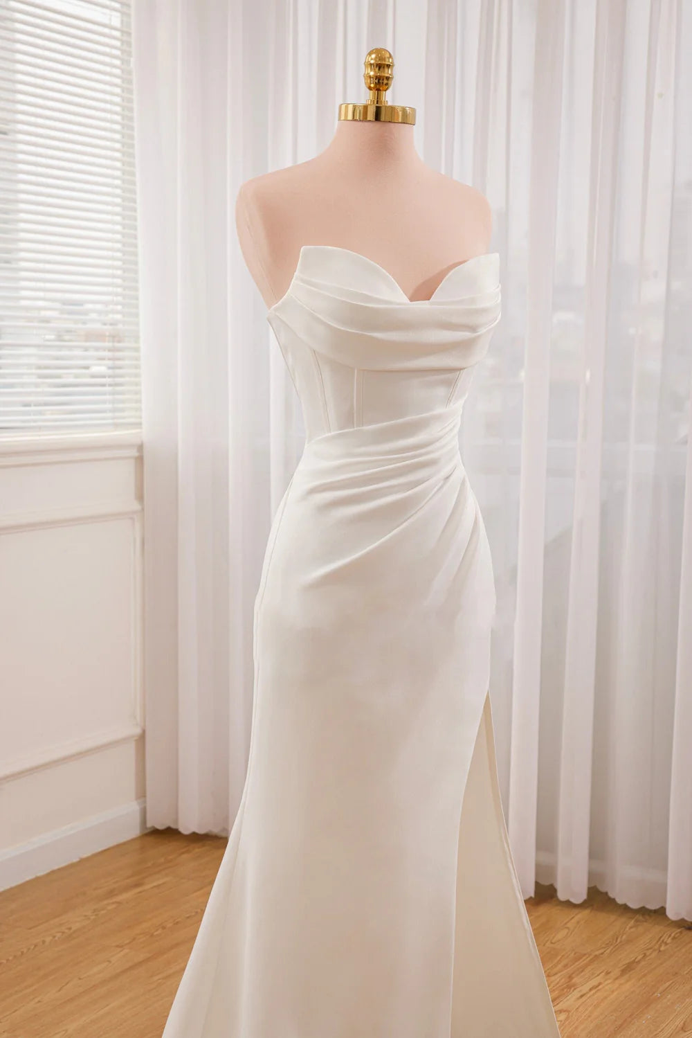 Close-up of the satin fabric and off-shoulder detail on a wedding dress.