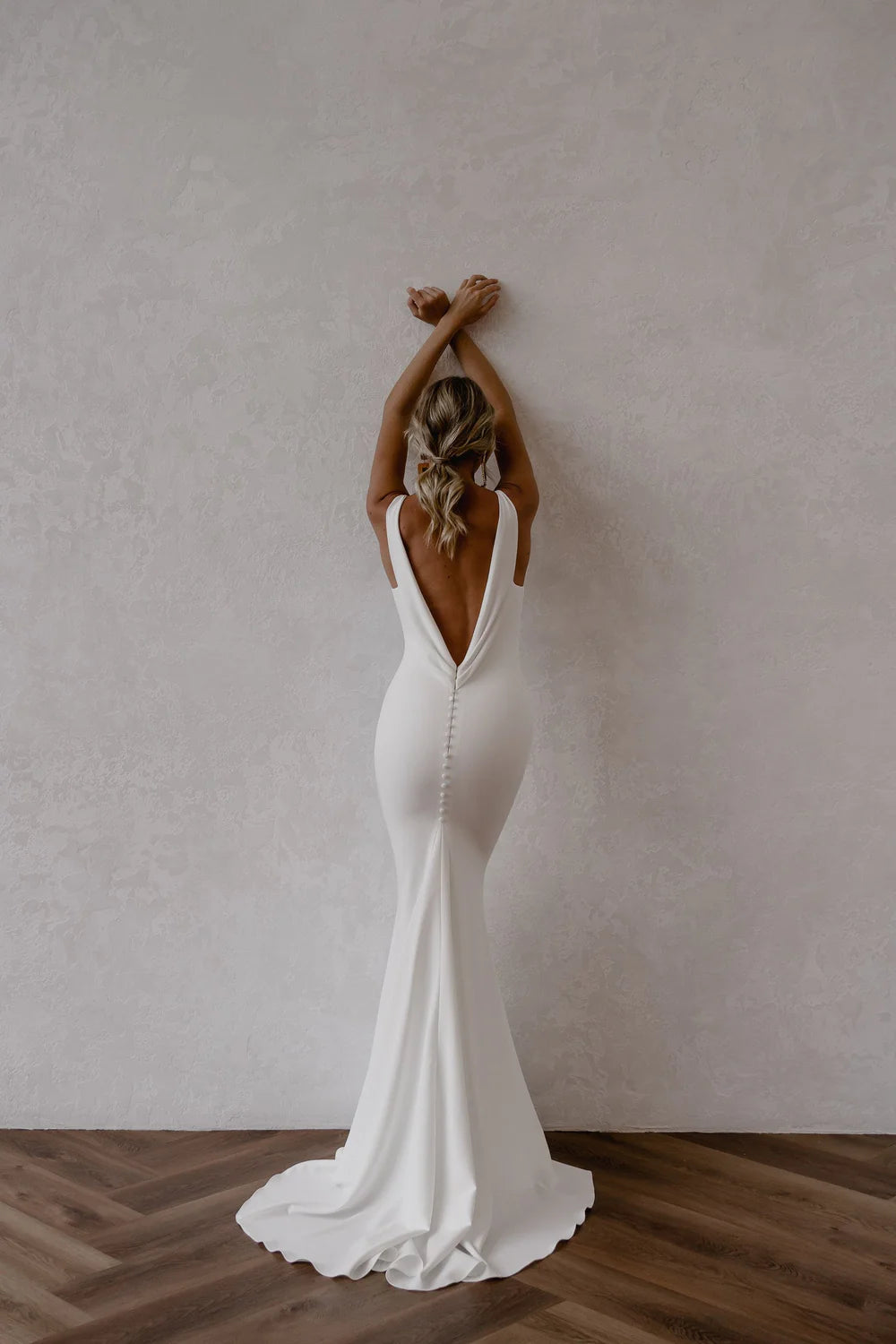 Side view of the white mermaid wedding gown, showcasing its silhouette and train.