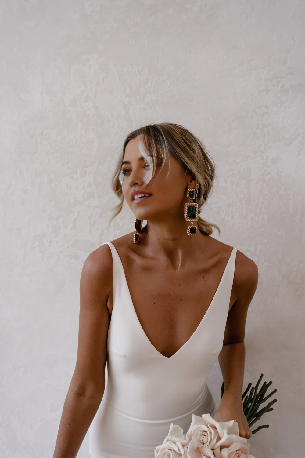Back view of the white wedding dress, highlighting the deep V-neck and backless design.