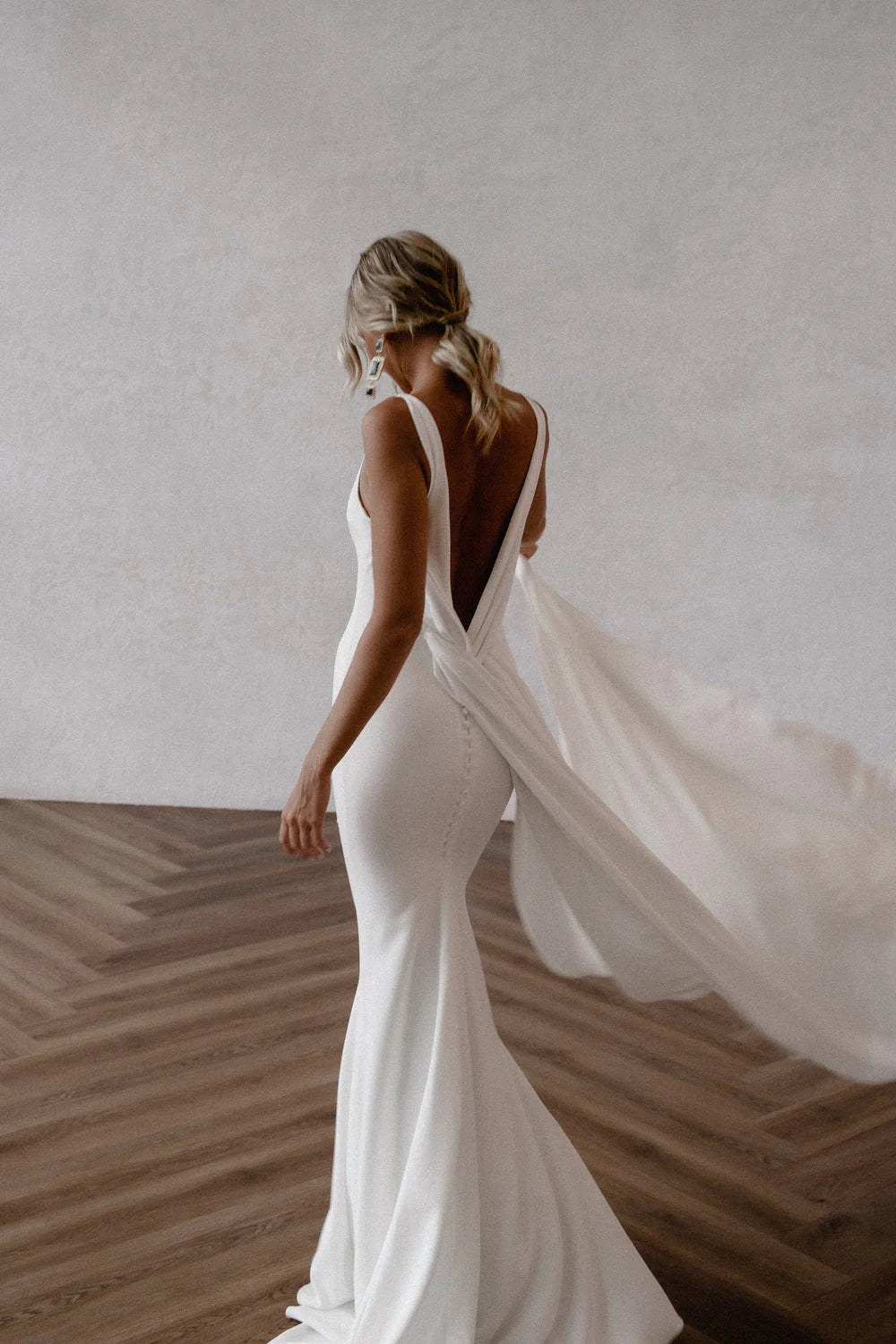 Close-up of the mermaid silhouette and flowing train of the white bridal gown.