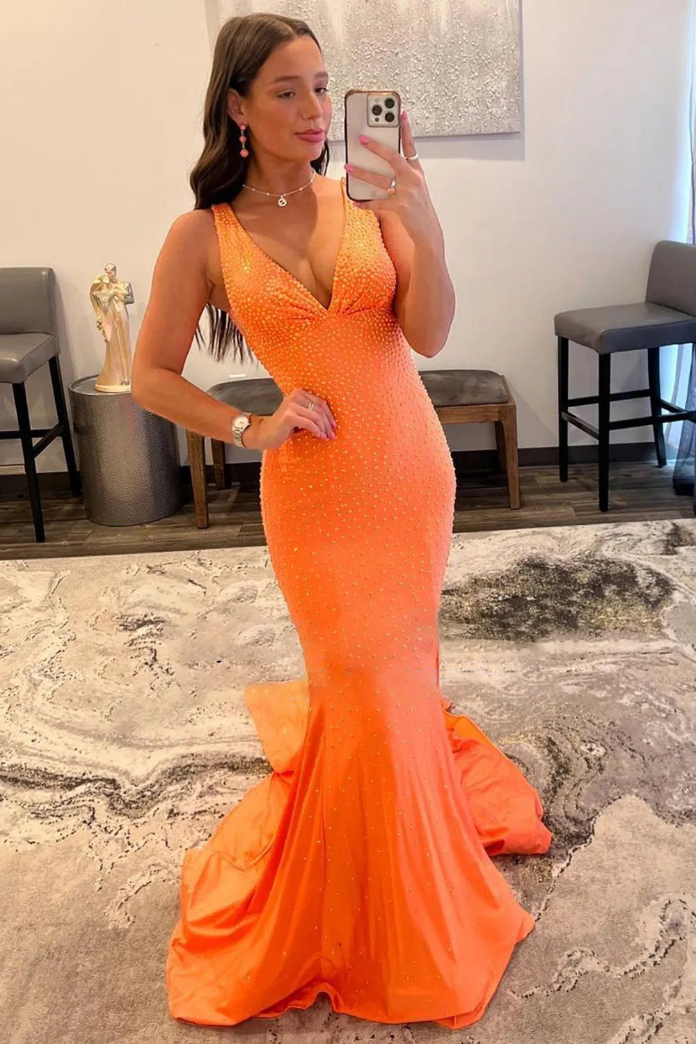 Elegant mermaid prom dress with deep V-neck and intricate beading.