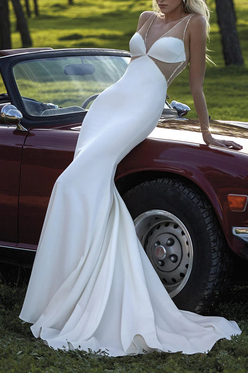 Elegant white mermaid wedding dress with deep V-neck and intricate beadwork.