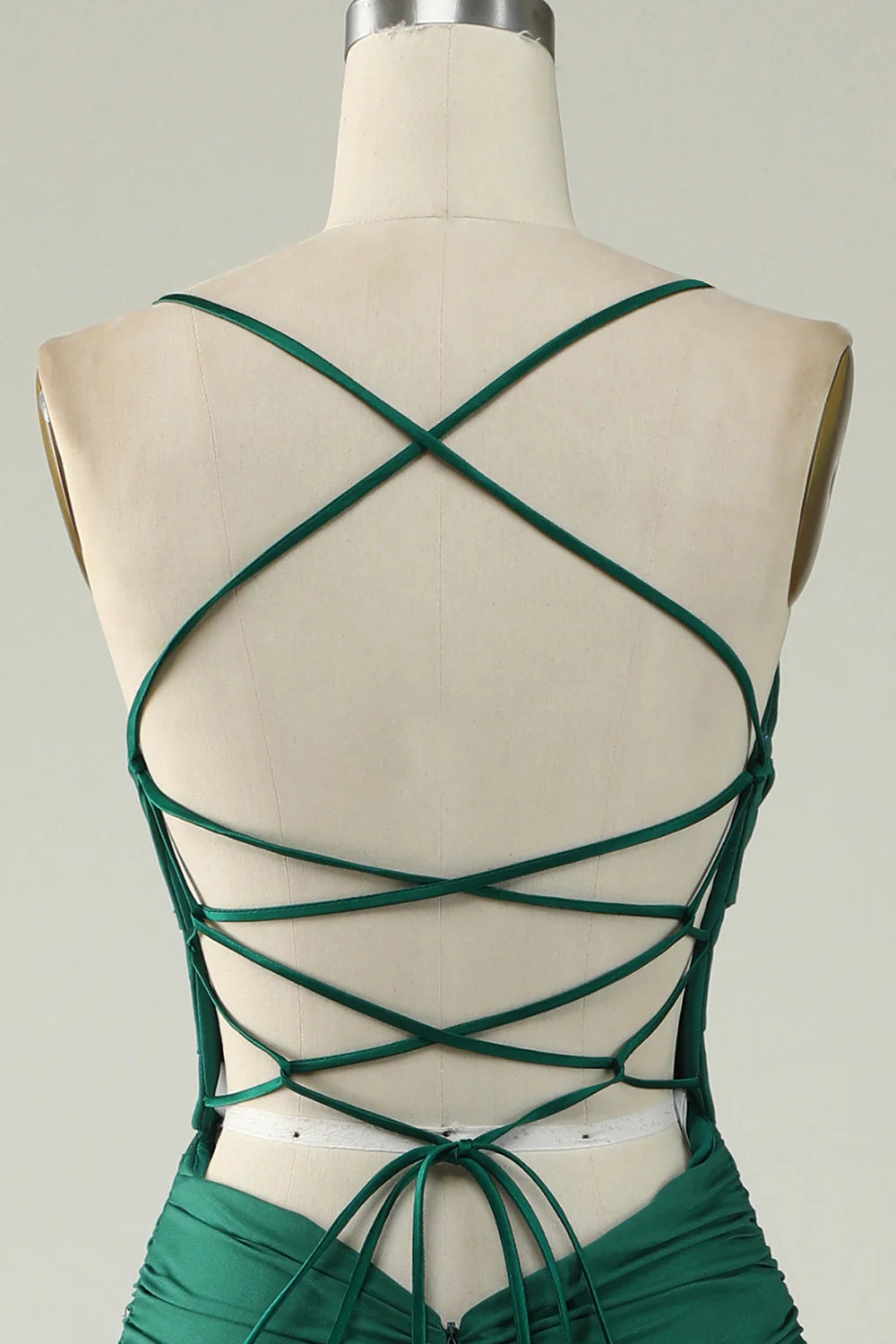 Close-up of the deep V-neckline on a dark green mermaid prom dress.