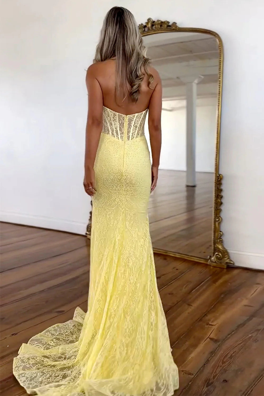 Back view of yellow mermaid formal dress showing backless design.