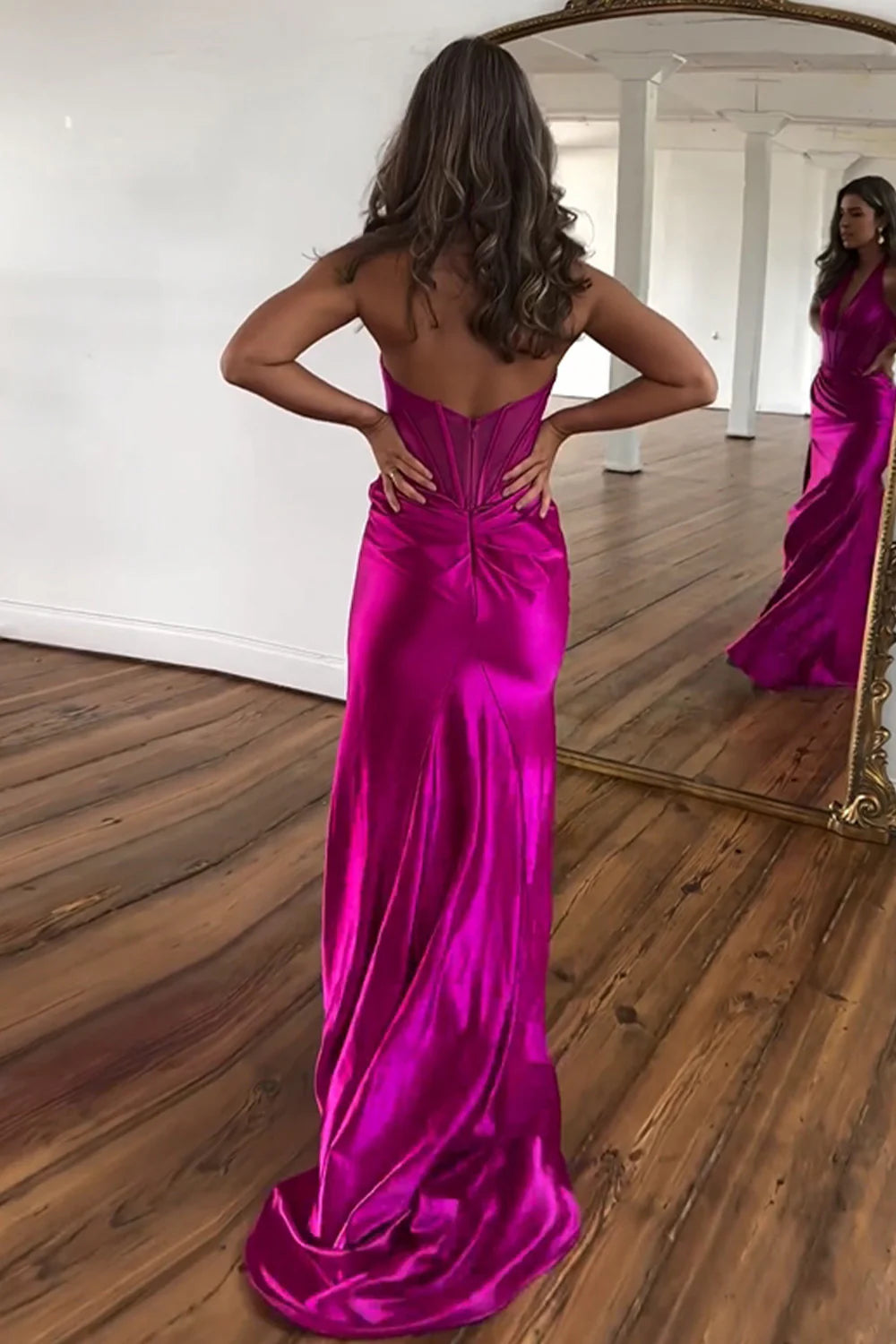 Back view of fuchsia satin mermaid dress showing backless design.