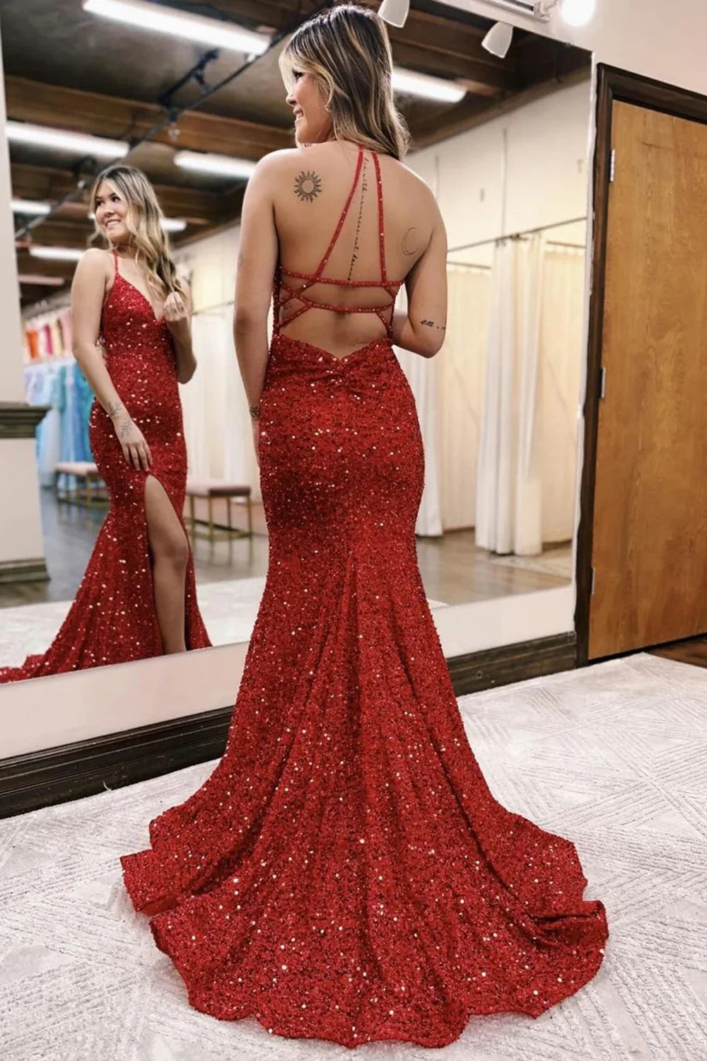 Back view of a red mermaid halter sequin dress, showing the train.