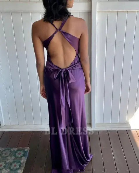 Back view of a woman wearing a purple mermaid halter V-neck satin long formal dress.