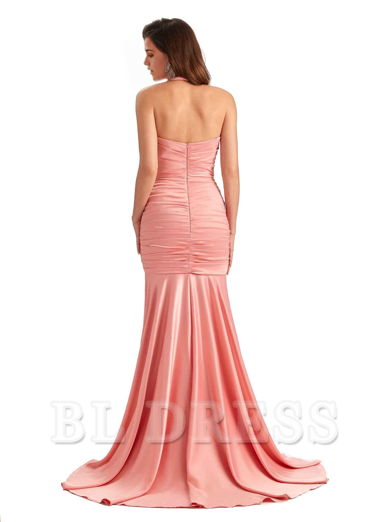 Woman in a blue mermaid halter V-neck satin formal dress with a side slit.