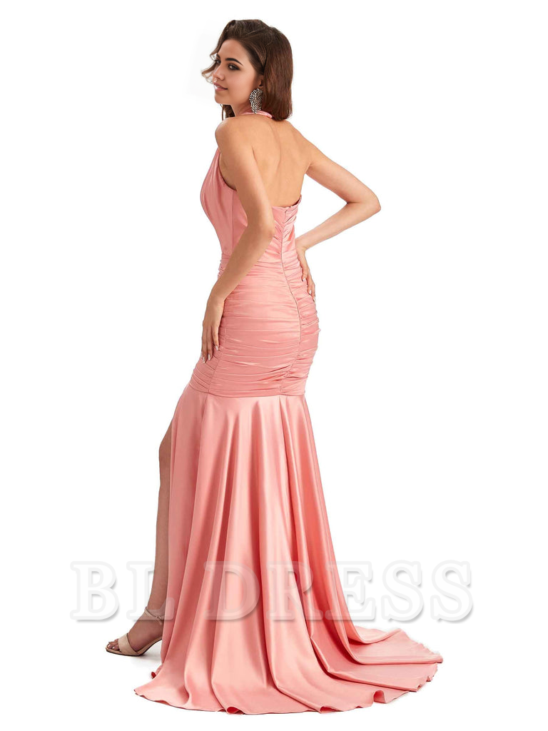 Woman in a green mermaid halter V-neck satin formal dress with a side slit.
