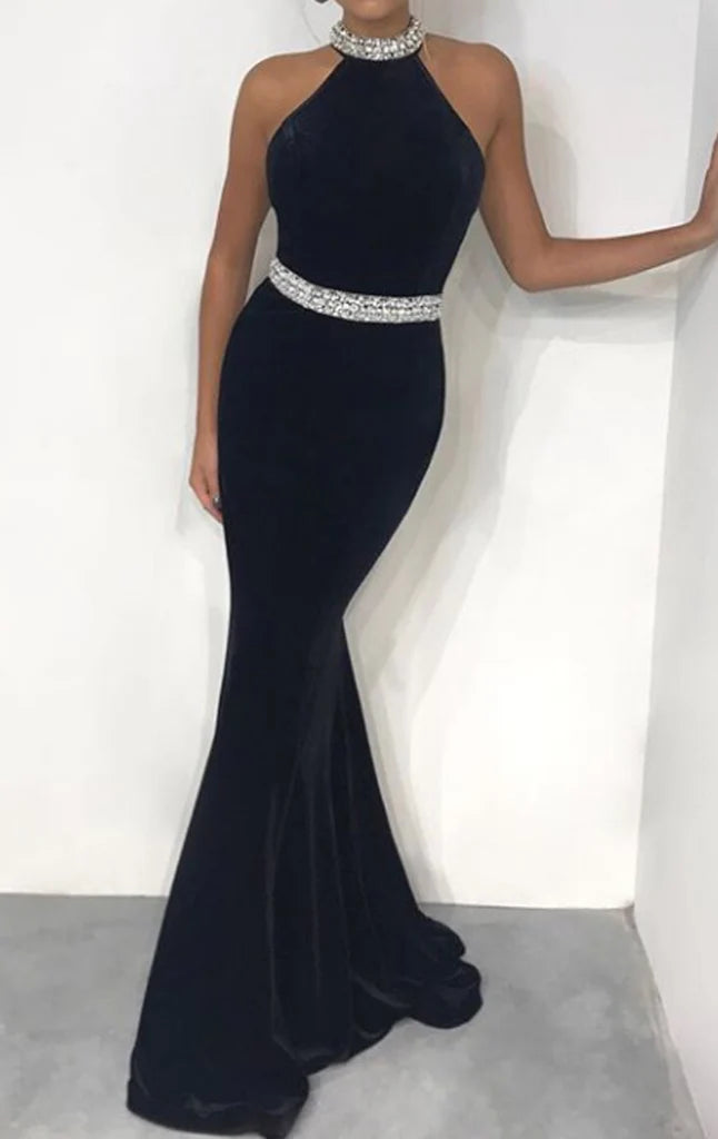 Woman wearing an elegant mermaid halter velvet long prom dress, front view.