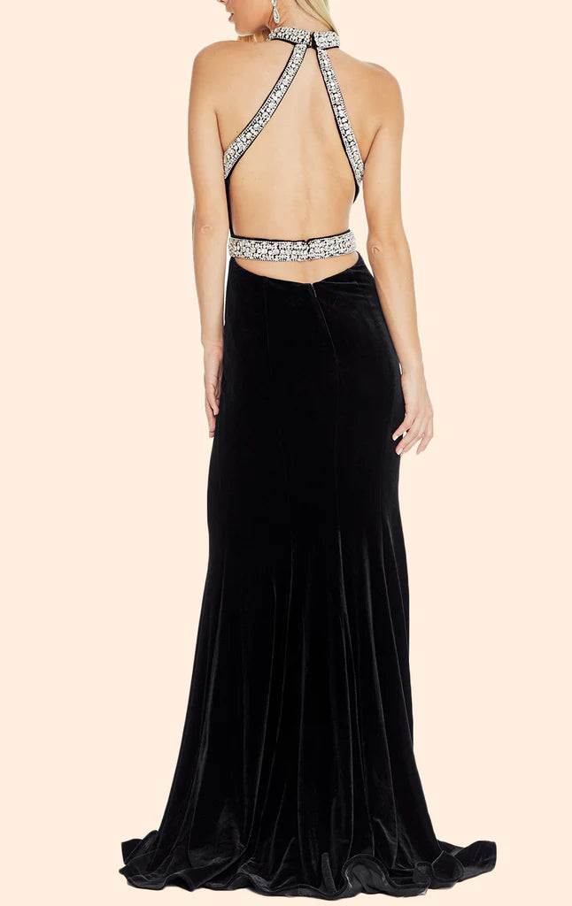 Back view of a woman in a luxurious mermaid halter velvet formal gown.