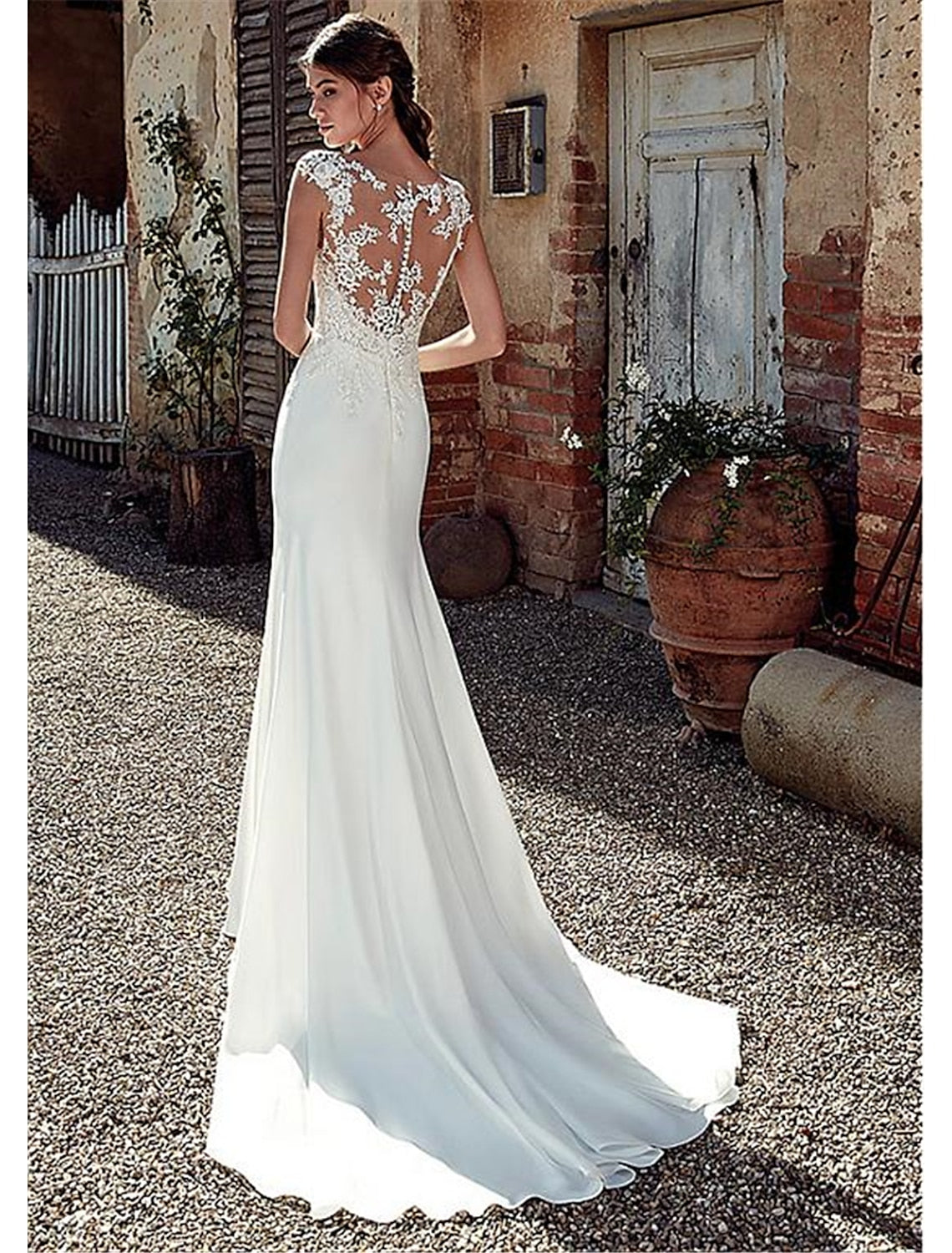 Back view of a mermaid wedding dress showing the open back design and court train.
