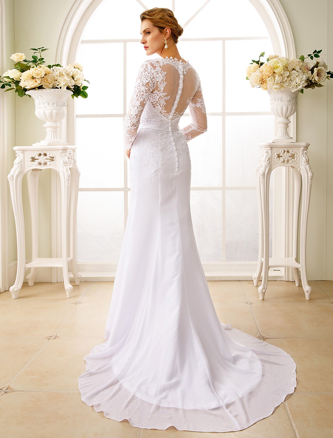 Back view of the bridal gown showing open back and court train.