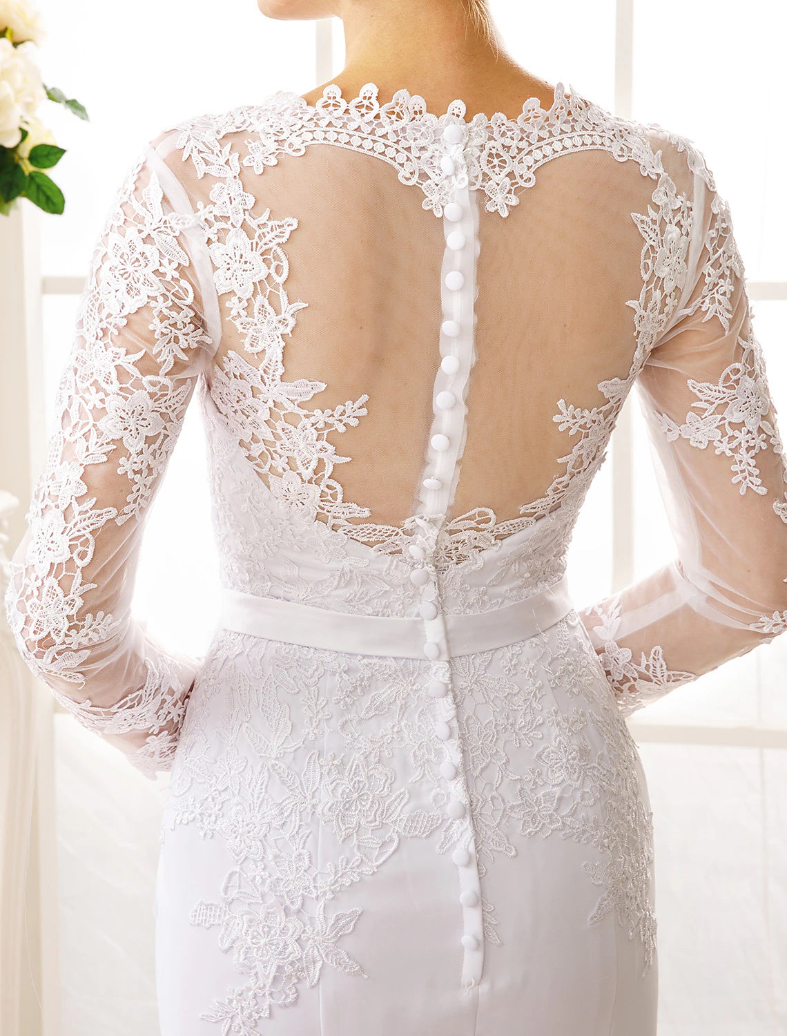 Close-up of illusion neck and long sleeve detail on wedding dress.