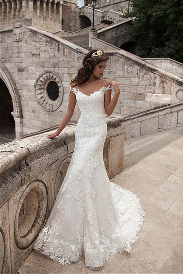 Elegant mermaid wedding dress with illusion neckline and lace details.