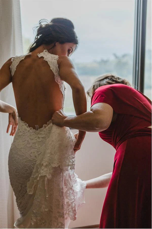 Mermaid bridal gown featuring an open back and dramatic split.
