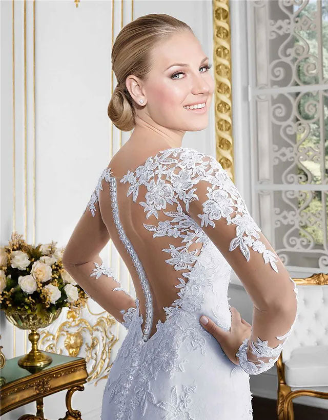 Side view of a bride in a mermaid wedding gown with illusion lace sleeves.