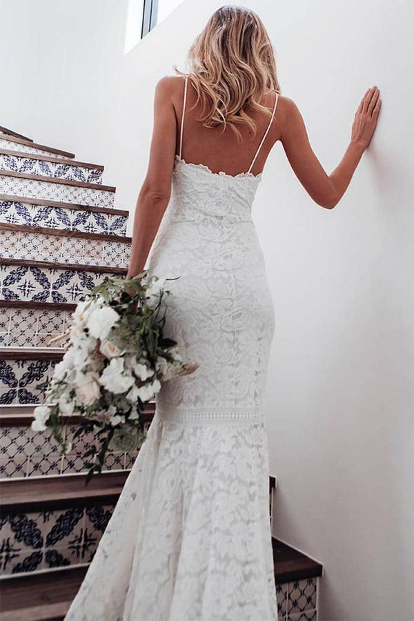 Back view of an ivory lace mermaid wedding dress with delicate spaghetti straps.