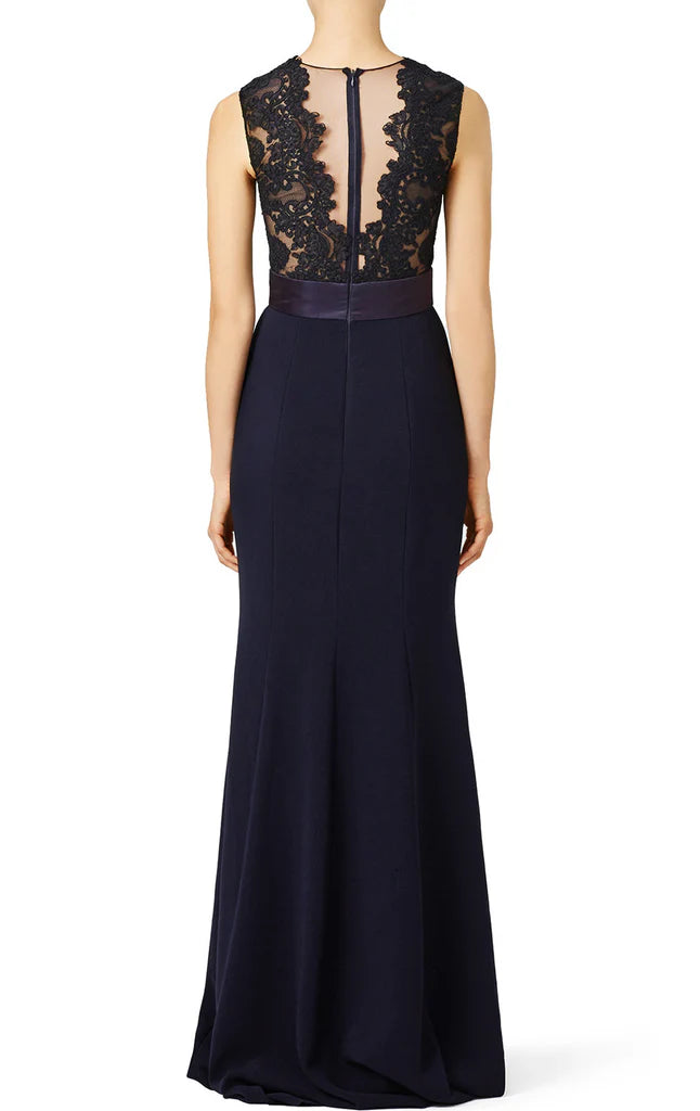 Back view of a woman in a long lace formal gown with a mermaid silhouette.