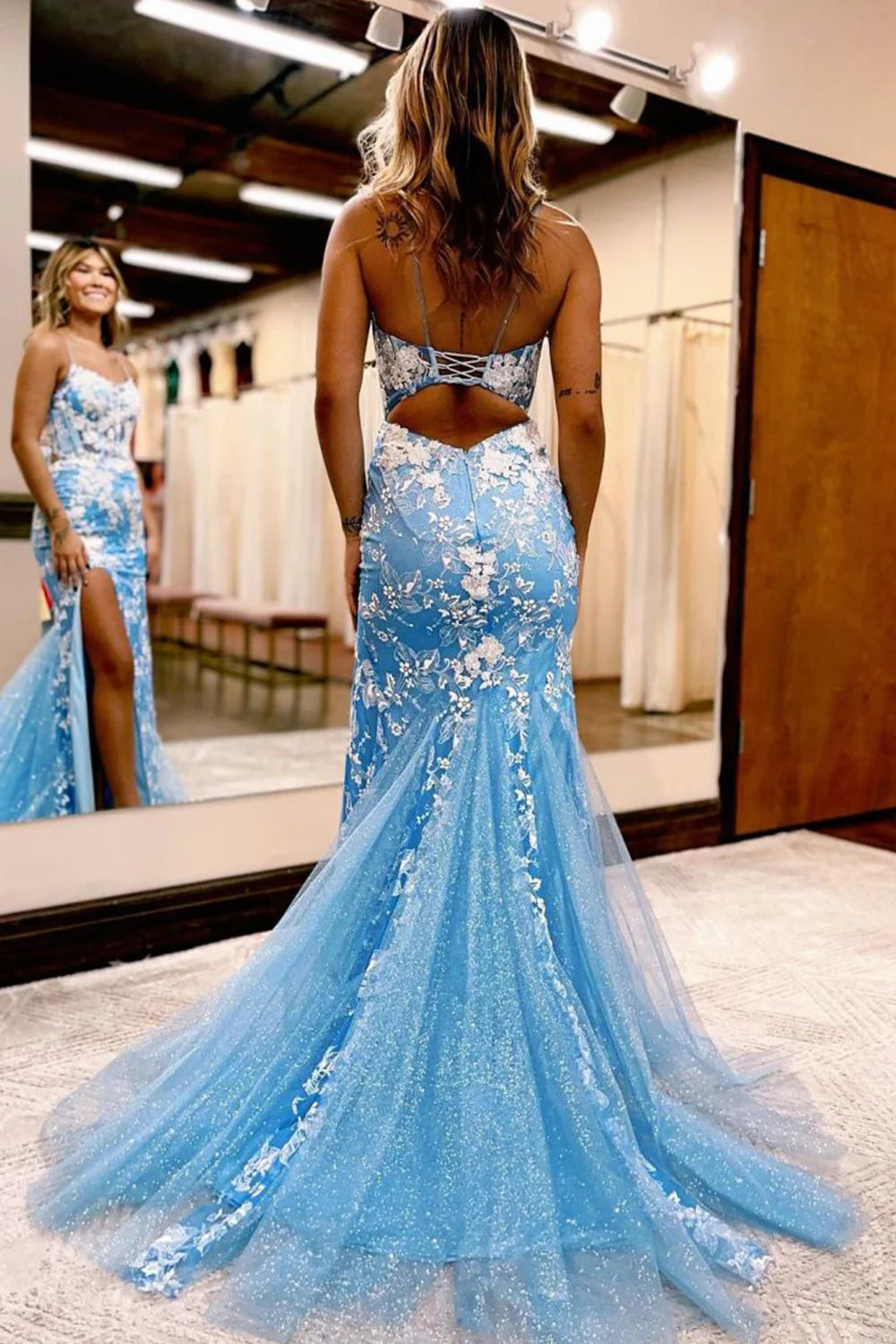 Mermaid lace gown showcasing open back detail and high leg slit.