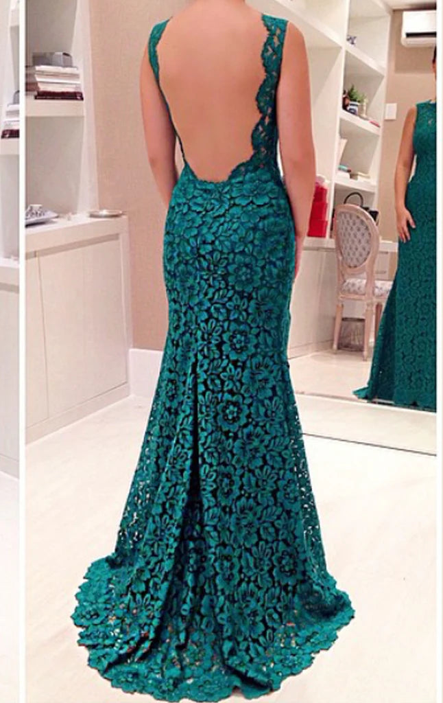Woman posing in a mermaid lace evening gown with a slit.