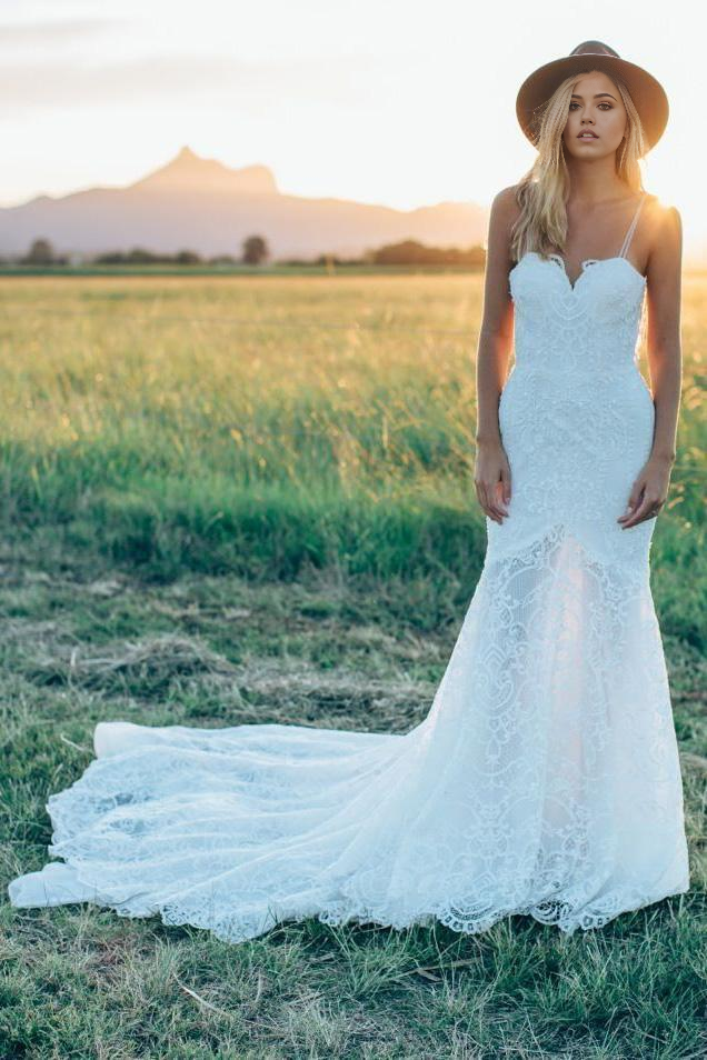 Ivory mermaid wedding dress with lace details and sweetheart neckline.