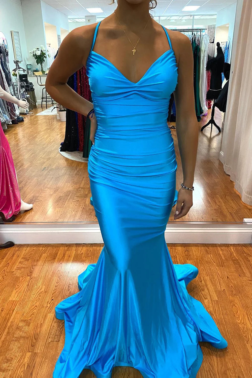 Back view of a sleeveless mermaid dress showing lace-up detail.
