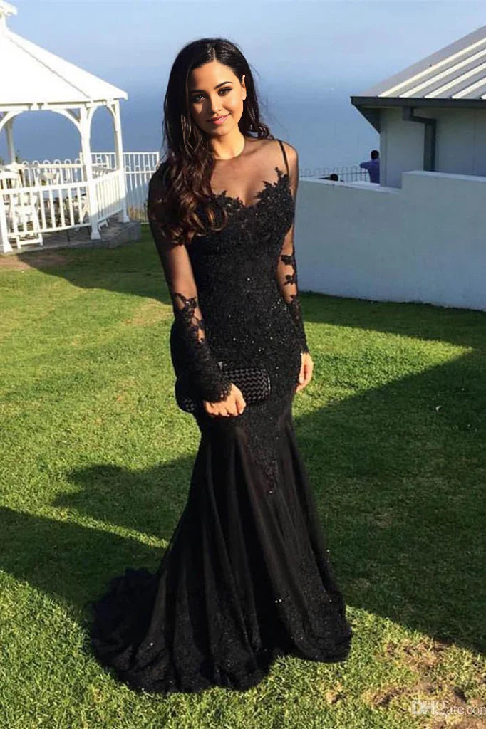 Woman wearing an elegant mermaid long sleeve prom dress with appliques.