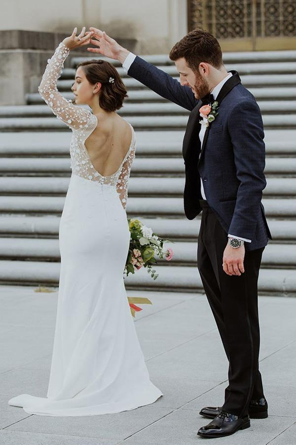 Back view of mermaid wedding dress showing open back and flowing train.