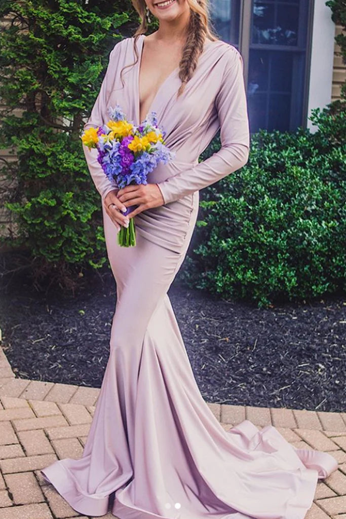 Elegant woman wearing a long sleeve V-neck mermaid formal dress in a dark color.