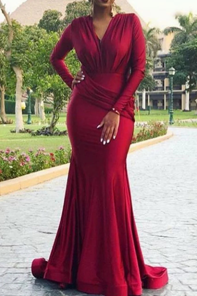 Side profile of a woman modeling a long sleeve V-neck mermaid formal dress, highlighting the silhouette.