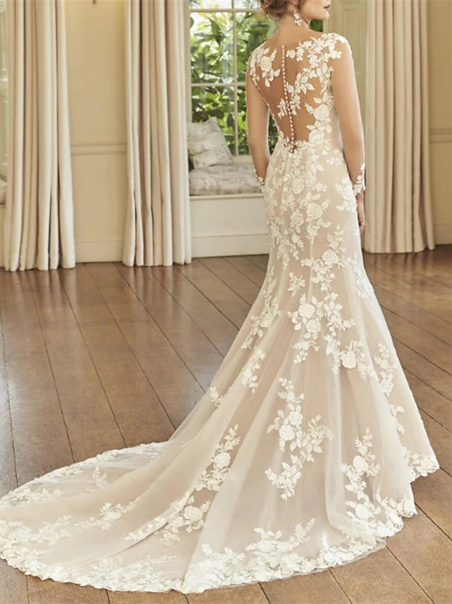 Close-up of the bodice and flowing court train of a mermaid long sleeve wedding dress.