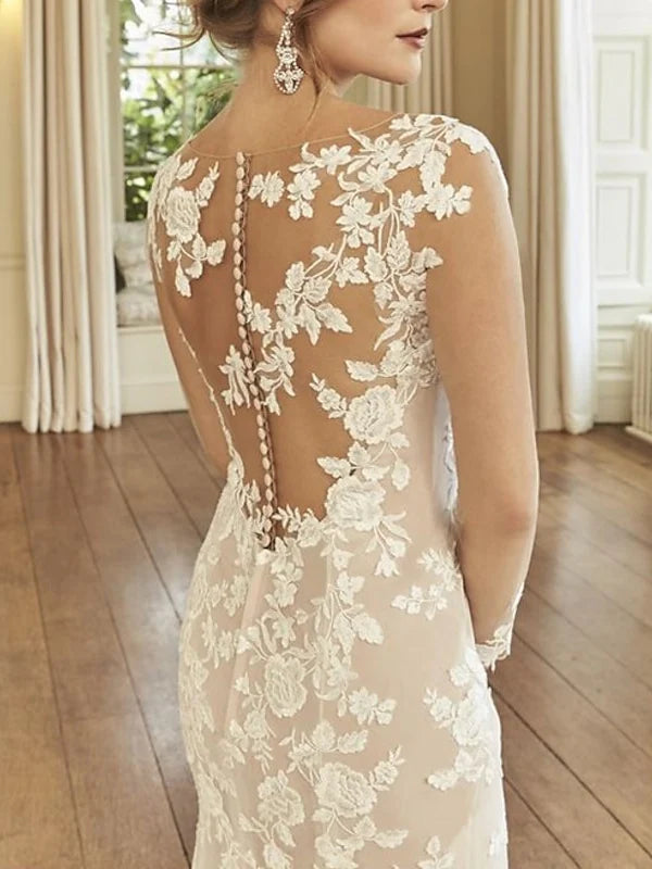 Side view of a bride in a mermaid long sleeve wedding dress, showcasing the elegant court train.