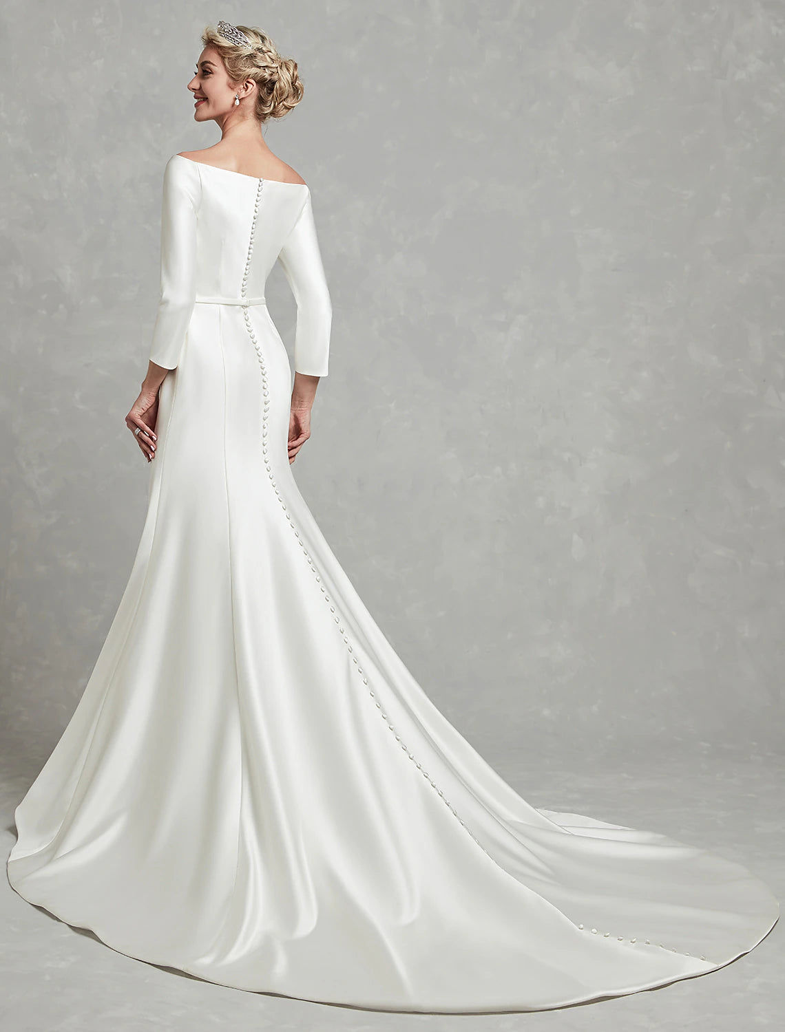 Side view of a sophisticated off-shoulder bridal gown, highlighting 3/4 sleeves and satin fabric.