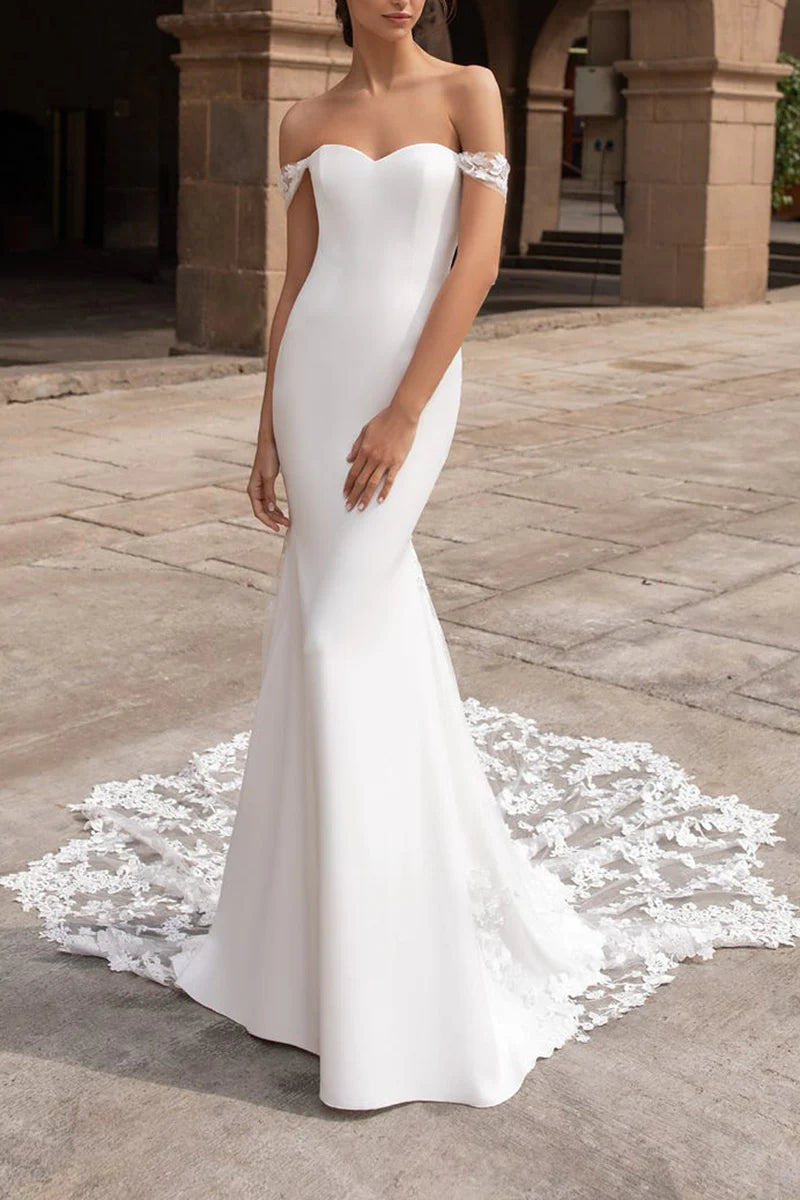 Full view of an elegant Mermaid Boho Off-Shoulder Lace Wedding Gown with a flowing train.