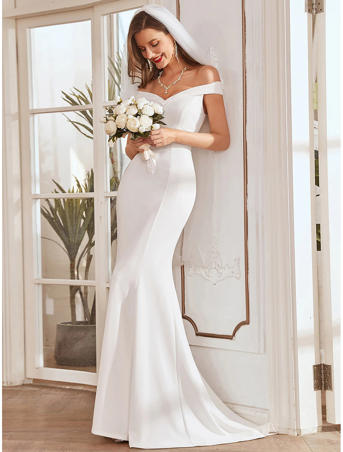 Back view of a mermaid off-shoulder cap sleeve wedding dress.
