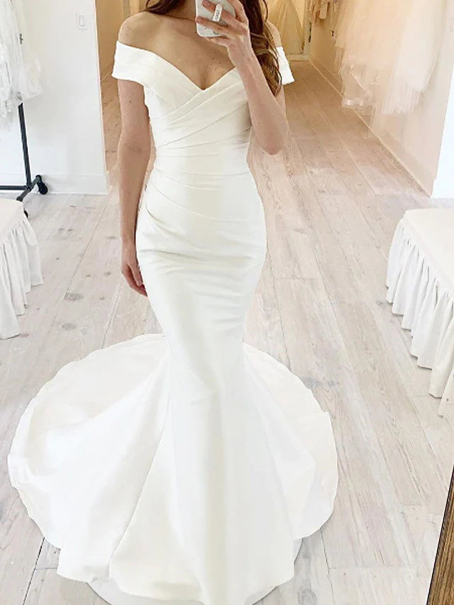 Elegant mermaid wedding dress with off-shoulder neckline and long skirt.
