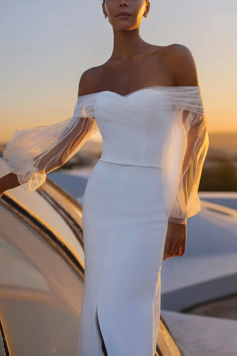 Close-up of the off-shoulder detail and long sleeves on a mermaid wedding dress.