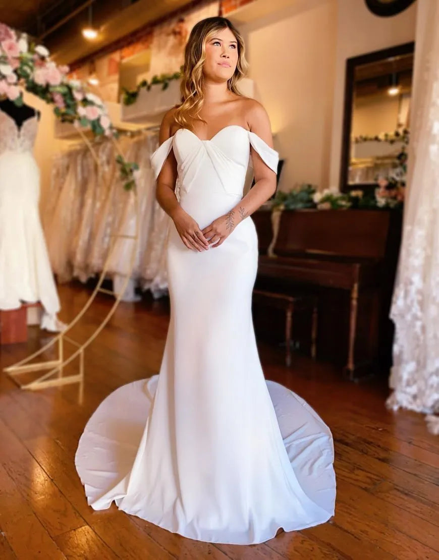 Elegant mermaid off-shoulder satin wedding dress, front view.