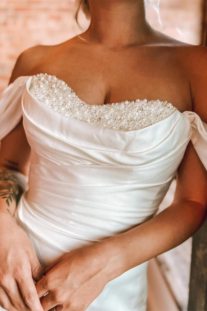 Side profile of the mermaid off-shoulder wedding dress, highlighting its silhouette.