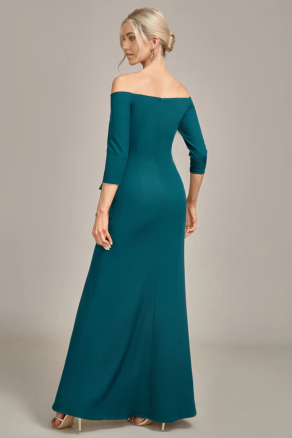 Side profile of a woman wearing a mermaid off-shoulder ruffled formal gown.