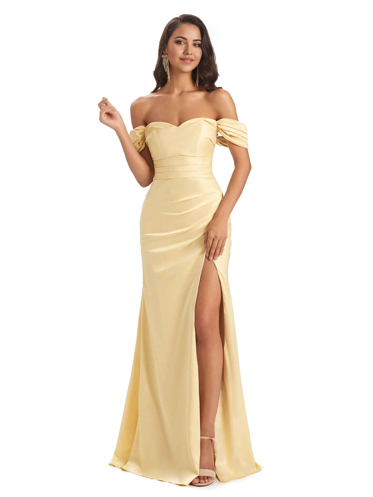 Woman wearing a long, elegant mermaid off-shoulder sweetheart satin gown with a side slit.