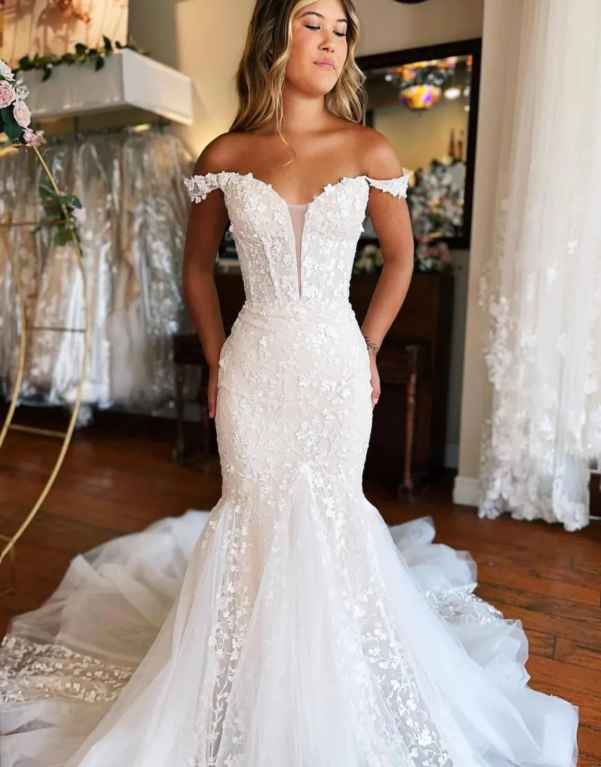 Side view of a white off-shoulder mermaid bridal gown.
