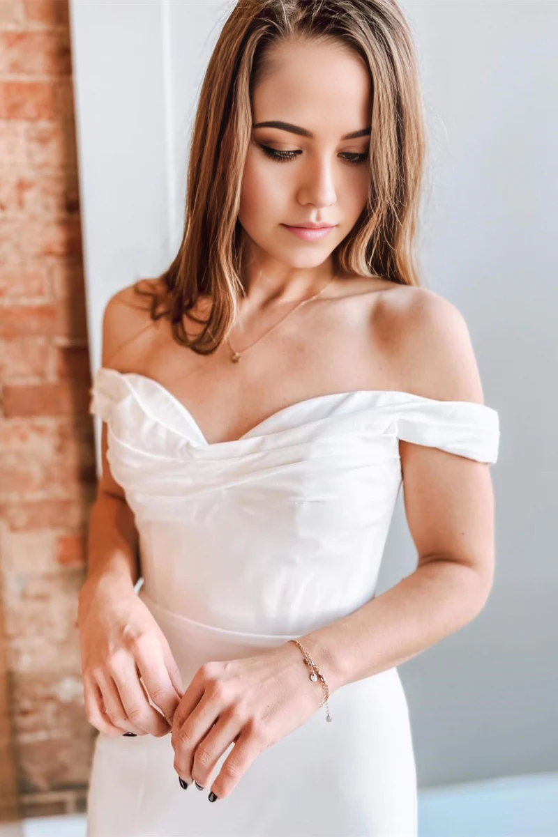 Side view of a bride wearing the mermaid off-shoulder wedding gown.