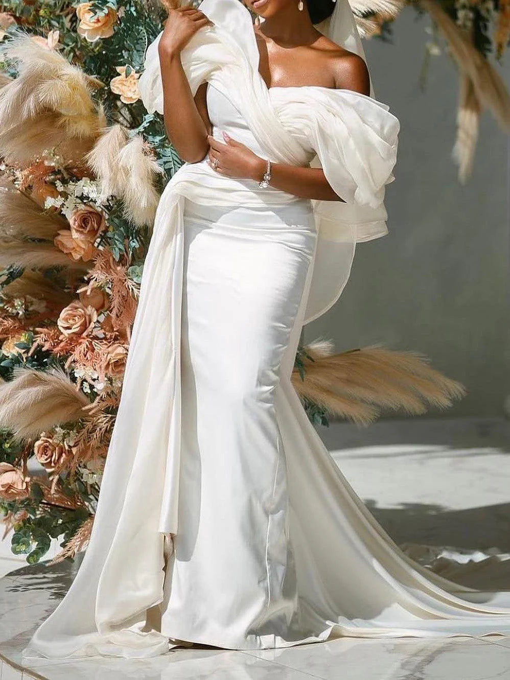 Bride wearing a mermaid off-shoulder wedding gown, full view.