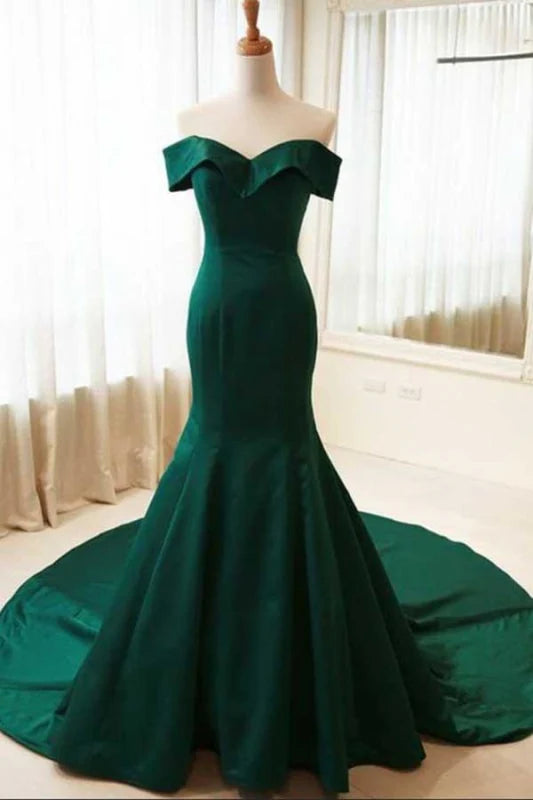 Woman wearing an elegant navy mermaid off-the-shoulder long prom dress.
